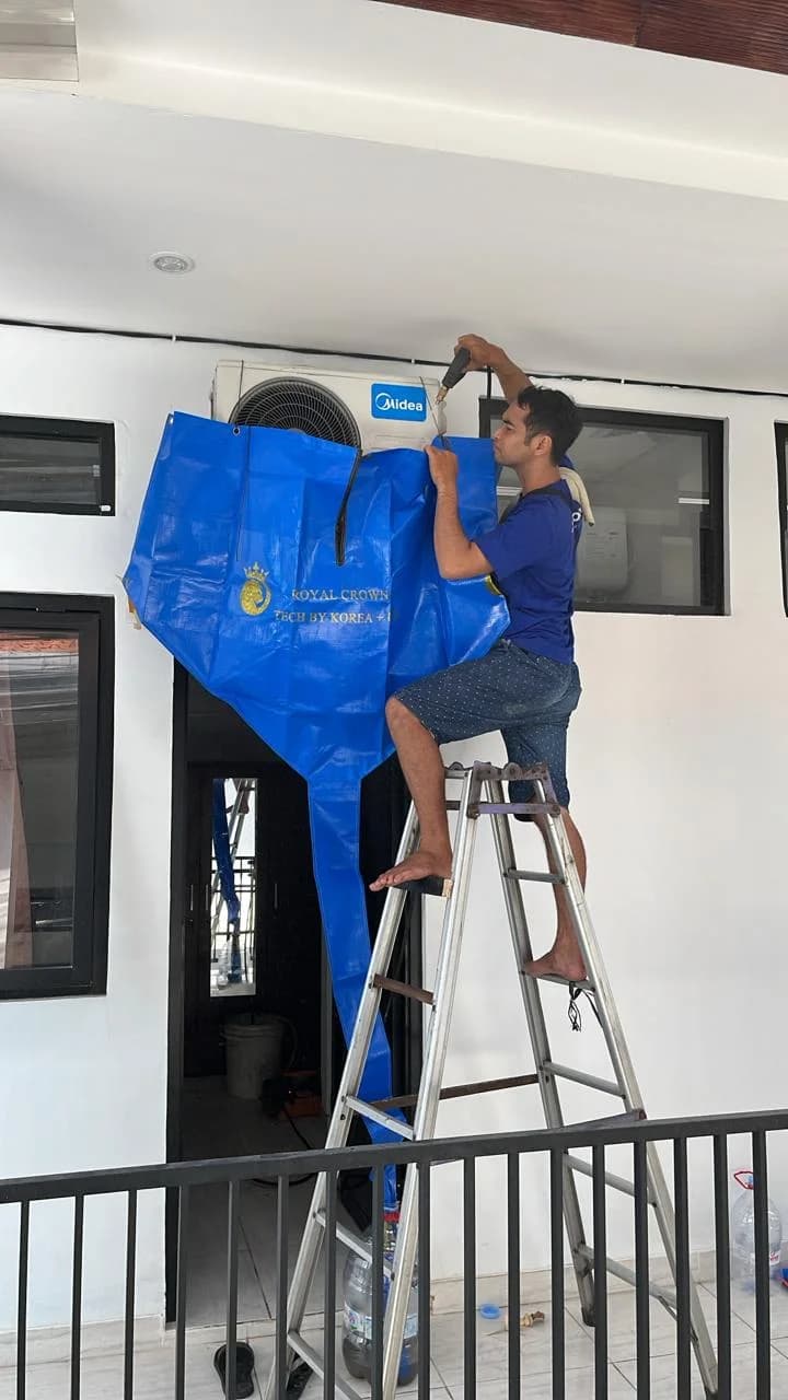 Teknisi melakukan bongkar pasang AC